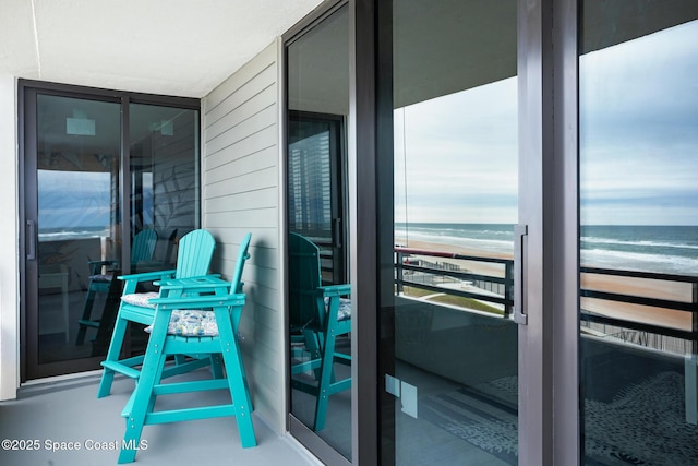 balcony featuring a water view and a view of the beach