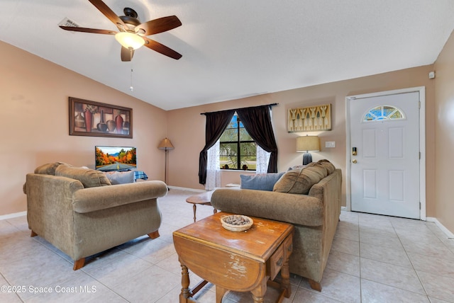 living room featuring ceiling fan, lofted ceiling, and light tile patterned flooring