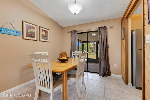 tiled dining area featuring a textured ceiling