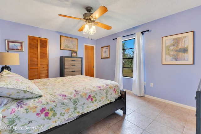 tiled bedroom featuring ceiling fan, a textured ceiling, and a closet