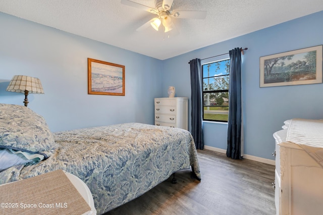 bedroom featuring ceiling fan, dark wood-type flooring, and a textured ceiling