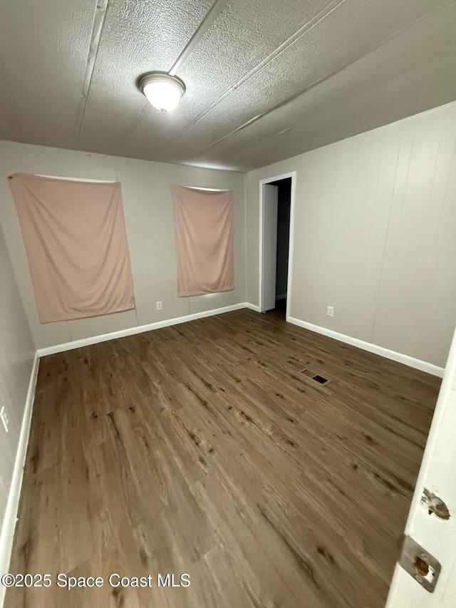 unfurnished room featuring hardwood / wood-style flooring and a textured ceiling