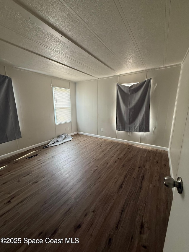 spare room featuring a textured ceiling and hardwood / wood-style floors