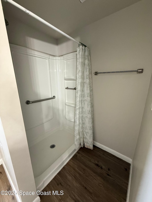 bathroom with wood-type flooring and walk in shower