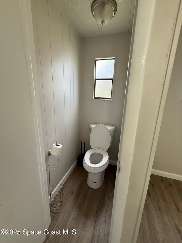 bathroom featuring toilet and wood-type flooring