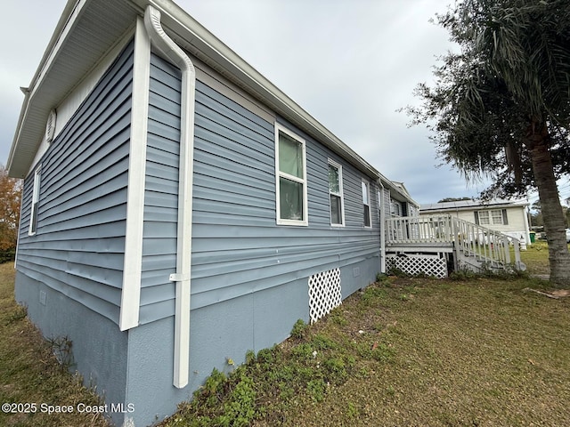 view of home's exterior featuring a yard and a wooden deck