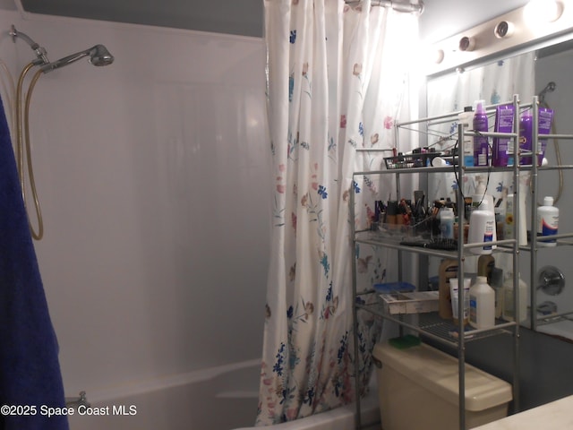 bathroom with toilet and shower / bath combo with shower curtain