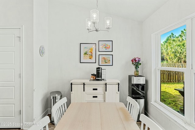 dining space with vaulted ceiling and a chandelier