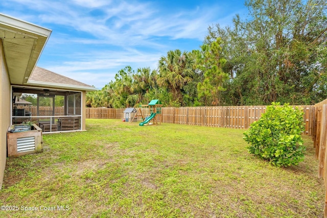 view of yard featuring a sunroom and a playground