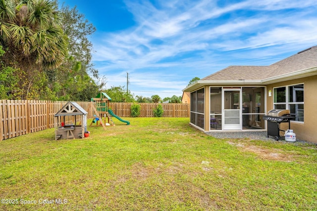 view of yard with a playground and a sunroom