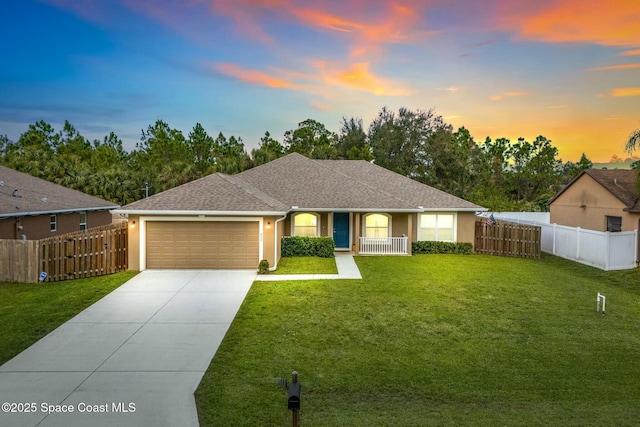 view of front facade with a garage, a lawn, and covered porch