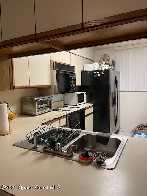 300 Columbia Dr Unit 5051, Cape Canaveral, FL 32920 - kitchen featuring white cabinetry and stainless steel fridge with ice dispenser