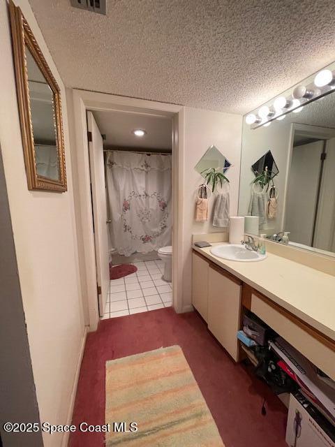 300 Columbia Dr Unit 5051, Cape Canaveral, FL 32920 - bathroom with vanity, tile patterned floors, a textured ceiling, and toilet