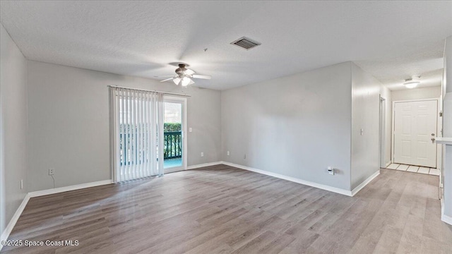 unfurnished room with light wood-type flooring, ceiling fan, and a textured ceiling