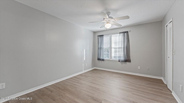 unfurnished bedroom with ceiling fan, a closet, a textured ceiling, and light hardwood / wood-style flooring