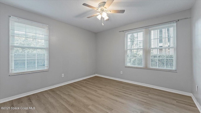 unfurnished room featuring light wood-type flooring, ceiling fan, and a textured ceiling