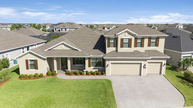 view of front of house featuring a porch, a front yard, and a garage