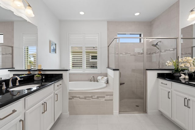 bathroom with separate shower and tub, a healthy amount of sunlight, and vanity