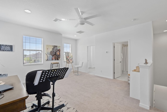 carpeted office space featuring ceiling fan