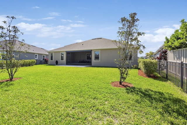 back of property with a lawn and a sunroom