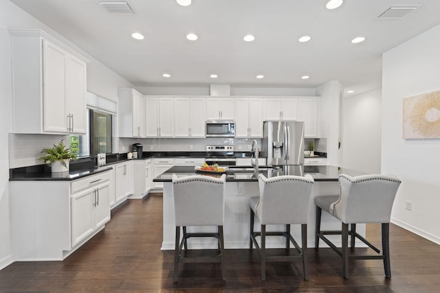 kitchen featuring white cabinets, stainless steel appliances, a center island, and sink