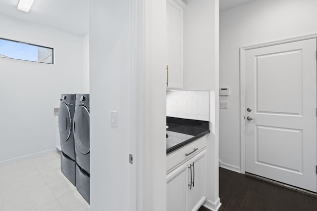 washroom featuring cabinets and washing machine and clothes dryer