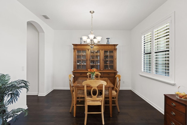 dining area with dark hardwood / wood-style flooring and a chandelier