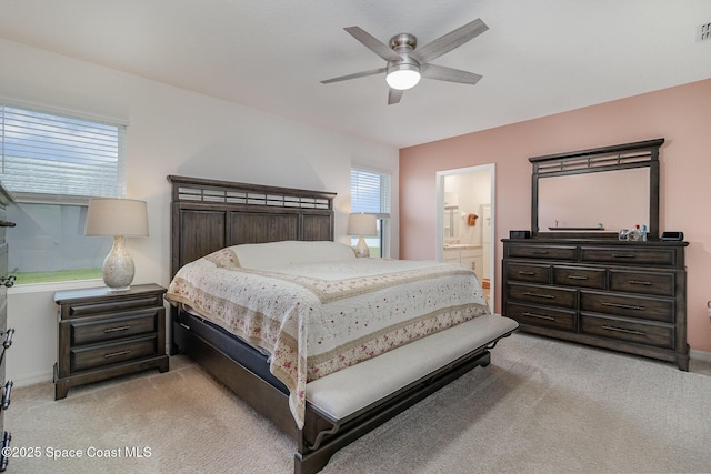 carpeted bedroom featuring ceiling fan and ensuite bath