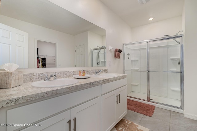 bathroom with vanity, a shower with shower door, and tile patterned floors