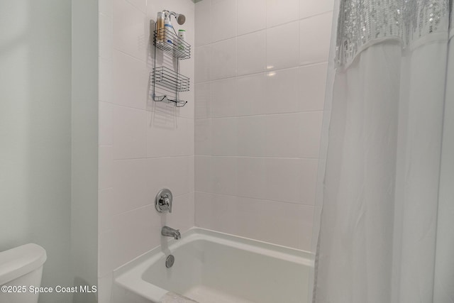 bathroom featuring shower / tub combo with curtain and toilet