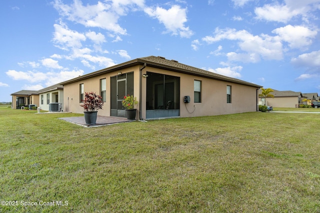 back of house with central air condition unit and a lawn