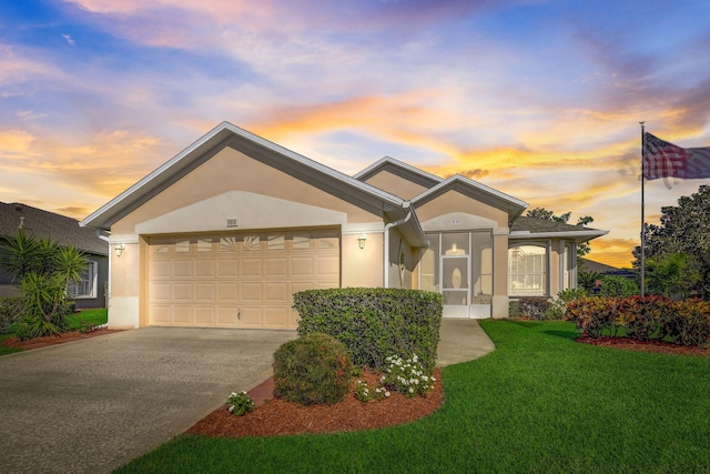 single story home with a lawn and a garage