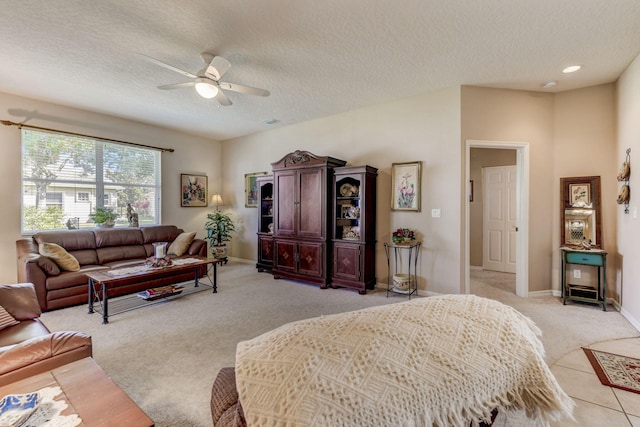 living room featuring a textured ceiling, ceiling fan, and light carpet