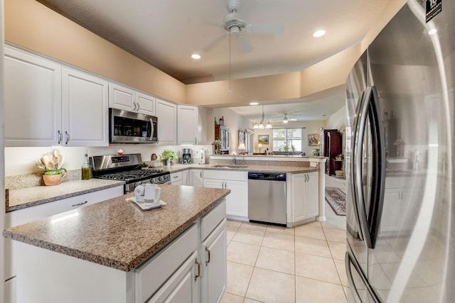 kitchen featuring stainless steel appliances, sink, white cabinetry, light tile patterned floors, and kitchen peninsula