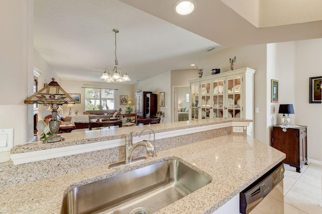 kitchen featuring sink, dishwasher, light stone counters, light tile patterned floors, and a chandelier