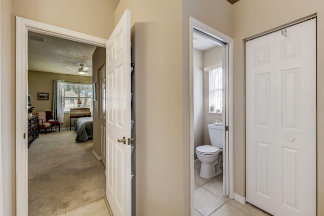 bathroom with toilet, ceiling fan, tile patterned floors, and plenty of natural light