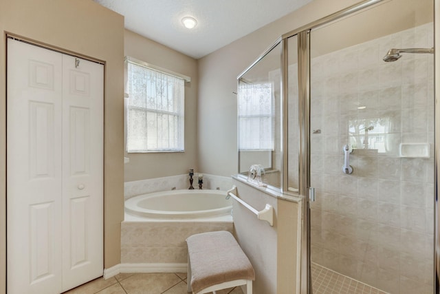 bathroom with tile patterned floors and shower with separate bathtub