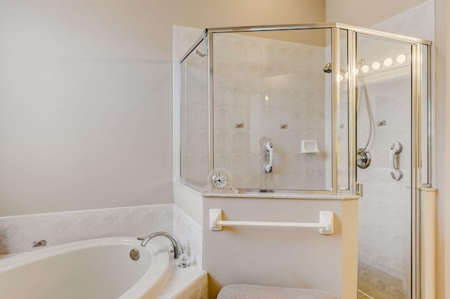 bathroom featuring shower with separate bathtub