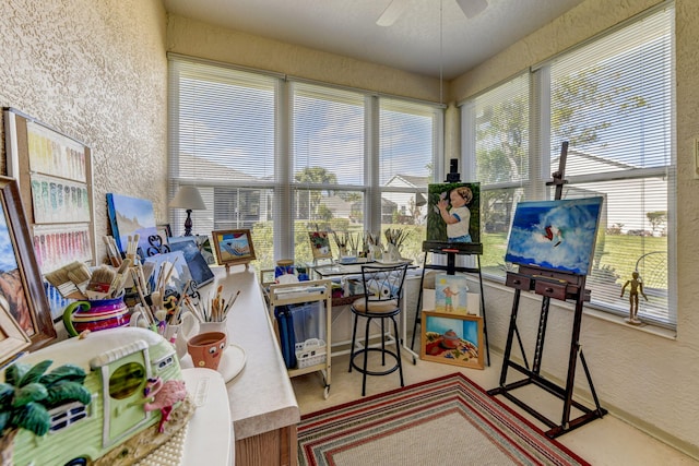 sunroom / solarium featuring ceiling fan and a wealth of natural light