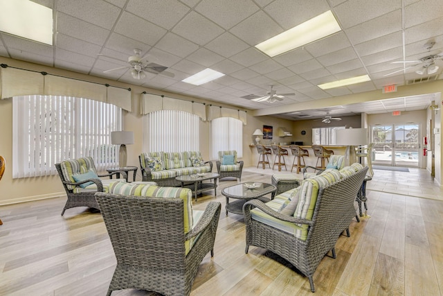 living room featuring a paneled ceiling, ceiling fan, and light hardwood / wood-style flooring