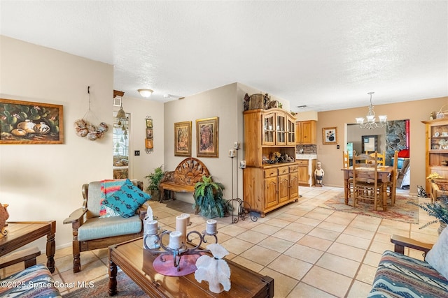 living room with an inviting chandelier, light tile patterned floors, and a textured ceiling