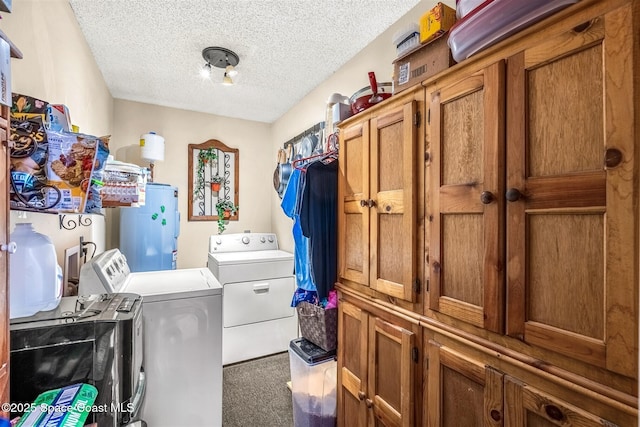 laundry room featuring water heater, cabinets, carpet, a textured ceiling, and washing machine and clothes dryer