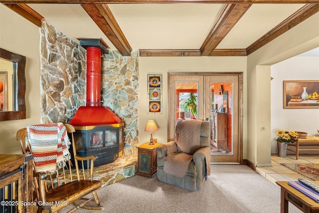 sitting room with a wood stove, french doors, beamed ceiling, and carpet