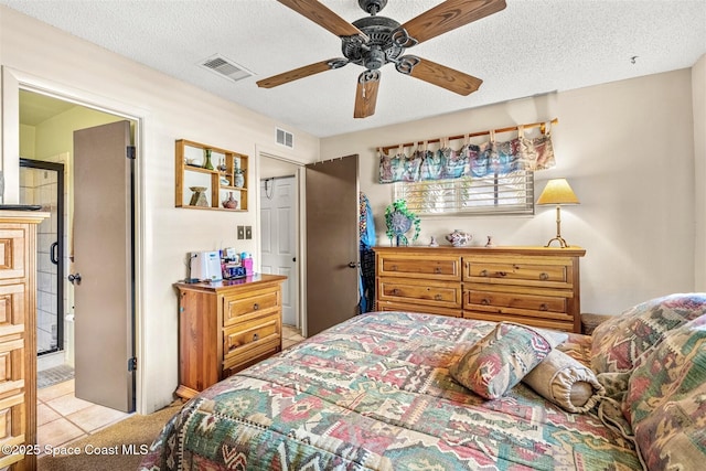 bedroom with ceiling fan, a textured ceiling, and light tile patterned floors