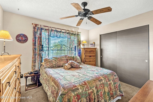 carpeted bedroom featuring ceiling fan, a closet, and a textured ceiling