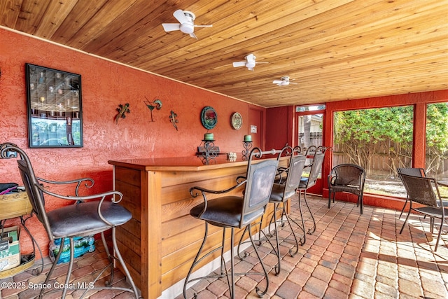 bar featuring a wealth of natural light, wooden ceiling, and ceiling fan