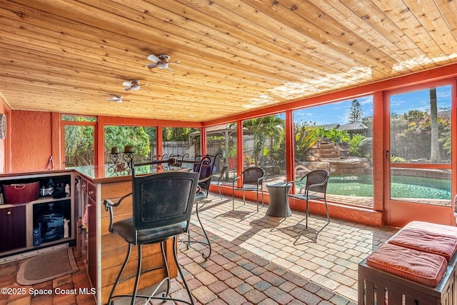 sunroom with wood ceiling and ceiling fan