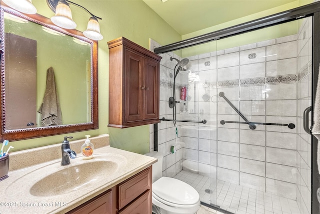 bathroom featuring a shower with door, vanity, and toilet