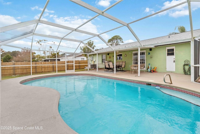 view of pool featuring glass enclosure and a patio