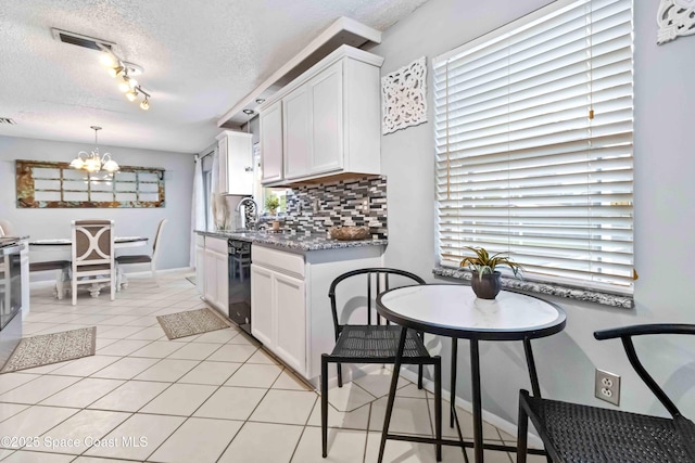 kitchen featuring white cabinets, decorative backsplash, an inviting chandelier, and a textured ceiling